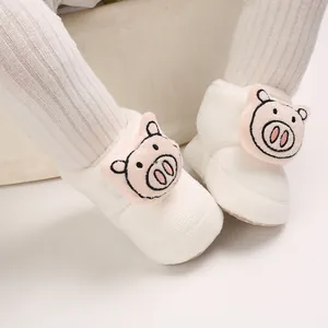Primer plano de botitas de algodón blanco antideslizantes para bebé con diseño de cerdito