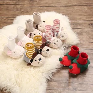 Detailed view of various cute cartoon animal baby walking shoes on a white plush rug