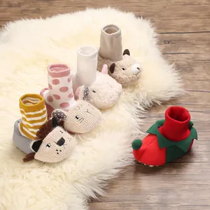 Collection of cozy cartoon animal baby walking shoes displayed on a soft white fluffy rug