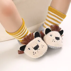 Macro view of cute cartoon lion baby soft-sole socks with yellow striped elastic bands