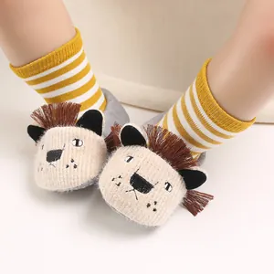 Close-up of soft-soled baby shoes featuring 3D lion face and yellow striped socks