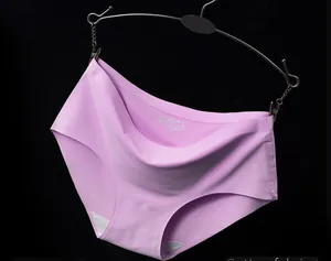 Detailed view of pink seamless ice silk panties hanging on a black metal hanger