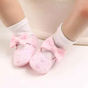 Detailansicht rosa Baby-Prinzessin-Schuhe mit Schleife und Herz-Stickerei-Details