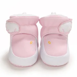 Detaillierte Makroansicht rosa Baby-Winterstiefel mit Plüschflügeln und Angel-Stickereidetails