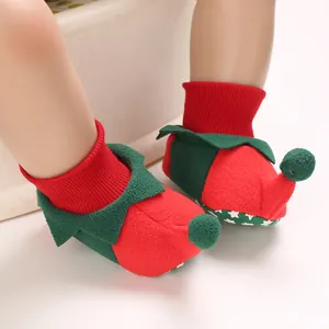 Close-up detail of elf-style Christmas baby booties with soft red knit and green fleece.