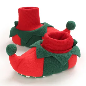 Detailed view of red and green Christmas elf baby booties with soft fleece.