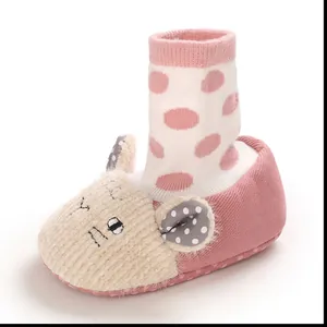 Detailed view of soft pink baby walking shoe with a cute cartoon face and polka dots
