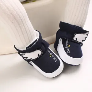 Nahaufnahme der dunkelblauen Baby-Schneeschuhe mit Engelsflügeln und weicher weißer Sohle