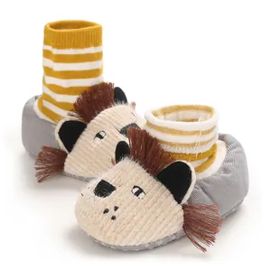 Close-up of cute lion baby walking shoes with warm yellow striped cuffs and soft soles.