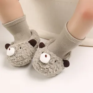 Close-up view of warm plush baby pre-walker shoes with cute cartoon bear design details.