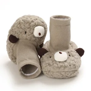 Detailed close-up of plush bear-themed baby snow boots with a soft knit sleeve