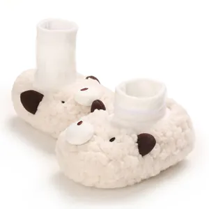 Close-up of soft fluffy bear-themed baby winter boots with elastic ribbed sock cuffs
