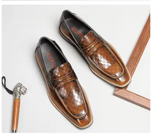Detail shot of brown embossed leather loafers with a square toe and checkerboard pattern