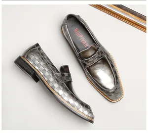 Detail of grey men's loafers featuring plaid embossed patent leather for formal business