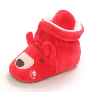 Dettaglio ravvicinato di scarpina invernale in morbido peluche rosso con orsetto