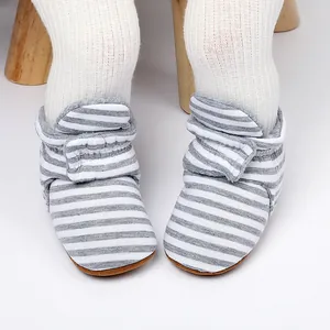 Close-up of gray striped fleece-lined baby winter booties with soft soles for infants