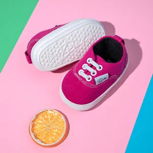 Primer plano de zapatos de bebé rosa con suela de goma antideslizante y tela de lona