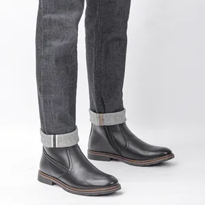 Vista detallada de botas de nieve negras para hombre con cremallera y costuras.