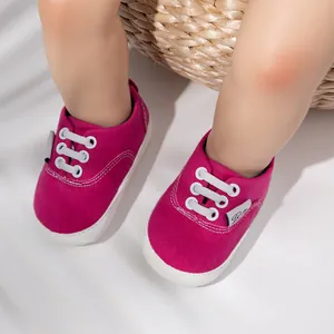 Vista detallada de zapatos de bebé rosa caramelo con cordones blancos y suela de goma