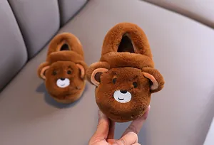 Détail macro de la texture en peluche marron sur de jolis chaussons d'hiver ours pour tout-petits