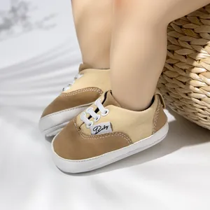 Primer plano de zapatos de bebé para caminar en lona marrón con suelas de goma