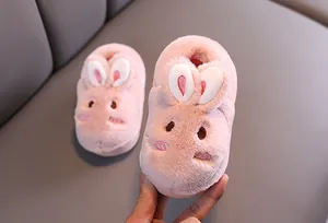 Gros plan de chaussons lapin en peluche rose pour bambin, texture polaire douce