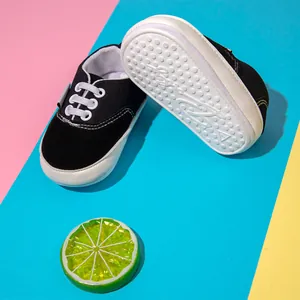 Primer plano de la suela de goma antideslizante en zapatos negros para bebés.