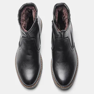 Vista superior de botas de invierno negras para hombre con forro de piel sintética marrón