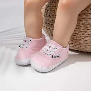 Primer plano detallado de zapatos de lona rosa para bebés con cordones blancos y suela