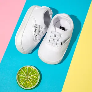 Vista superior de zapatos de lona blancos para bebé con suelas de goma antideslizantes
