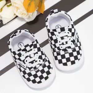 Vista detallada del patrón de tablero de ajedrez y suelas blandas en zapatos para bebés