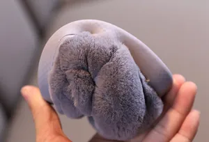 Gros plan d'un chausson en coton pour enfant montrant la semelle souple et la fourrure.