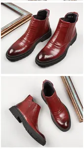 Detailed view of burgundy leather Chelsea boots with elegant brogue perforations.