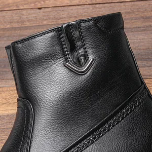 Primer plano de bota de nieve de cuero negro con logo V metálico y costuras finas