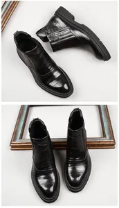 Detailed view of men's black leather Chelsea boots with elegant brogue carving and thick soles
