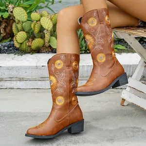 Vista detallada de botas altas marrones con bordado de girasol y tacones gruesos de moda