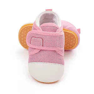 Close-up detail of pink baby walking shoes with breathable mesh and velcro straps.