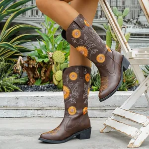 Vista detallada de botas vaqueras marrones con patrón bordado de girasoles.