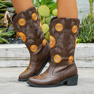 Detalle de botas marrones con tacón grueso y bordado de girasoles estilo campero