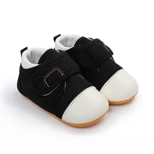 Macro view of breathable black mesh baby walking shoes with white toe caps and rubber soles