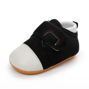 Close-up of black mesh baby walking shoe with white leather toe cap
