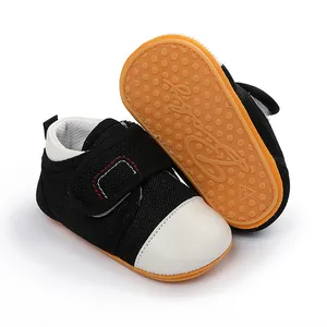 Close-up of black mesh baby walker shoes with anti-slip yellow rubber sole detail.