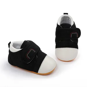 Detailed view of breathable mesh material and secure velcro strap on black baby walking shoes