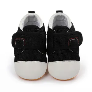 Front detail of breathable black mesh baby walking shoes with protective white toe.