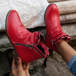 Detailed view of red vintage ankle boots with side zipper and gathered leather design