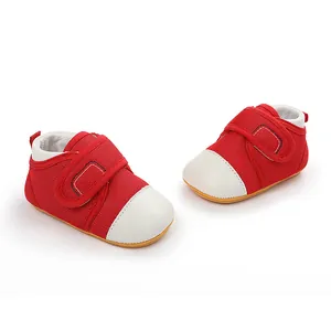Close-up view of red baby pre-walking shoes with white toe caps and velcro straps