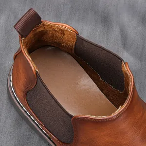 Gros plan d'une bottine Chelsea marron vintage montrant la doublure et le panneau élastique