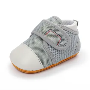 Detailed view of breathable grey mesh and white leather toe on baby walking shoes.