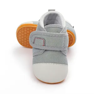 Breathable grey mesh baby walking shoes with non-slip orange rubber sole texture detail