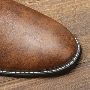 Détail macro de la pointe en cuir marron vintage sur une élégante bottine Chelsea pour homme